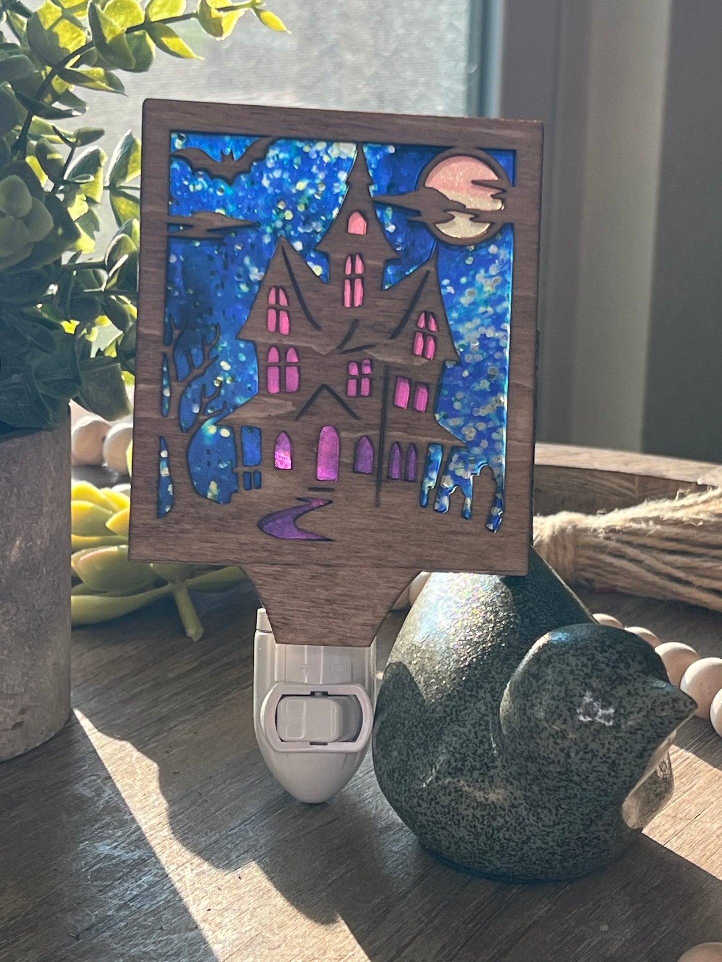 Haunted House Nightlight made of wood and acrylic, golden oak stained, rustic decor, front facing in sunlight..