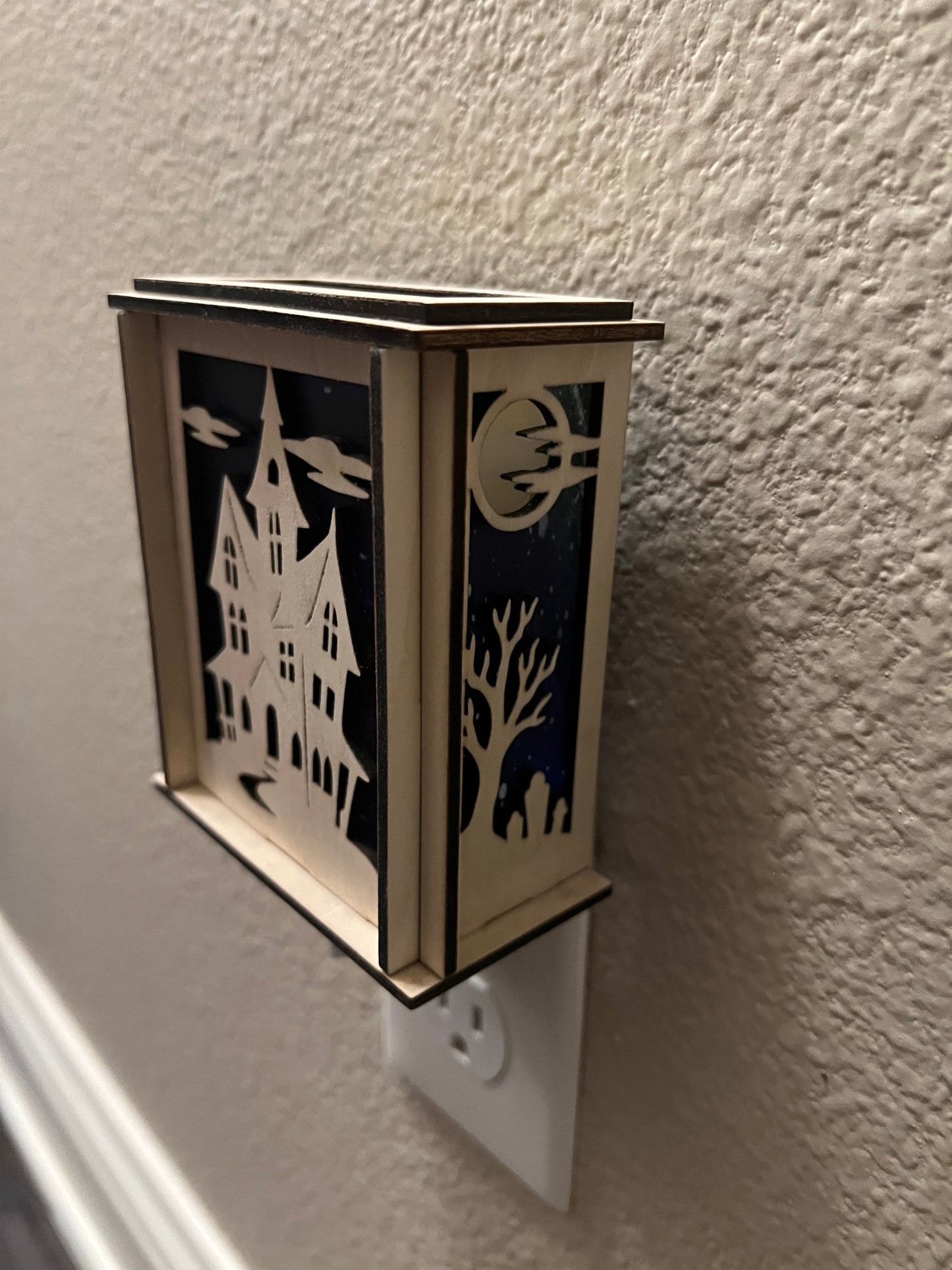 A haunted house-themed suncatcher with stained glass effect in black and multicolor acrylic - from right side.