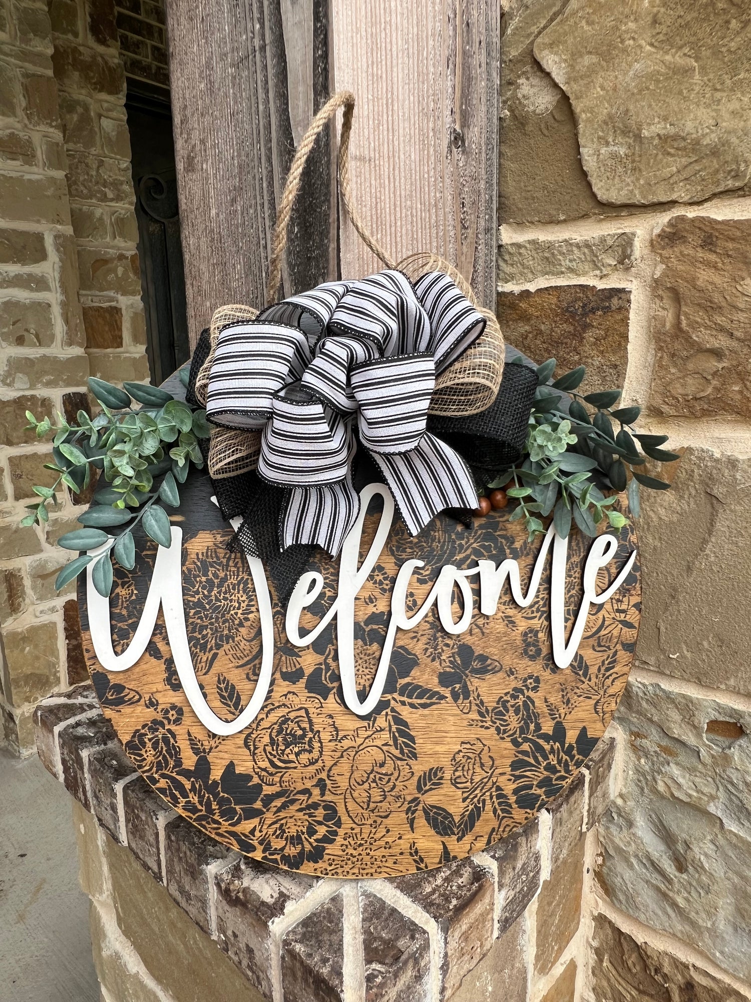 Laser-cut wood welcome sign with floral accents