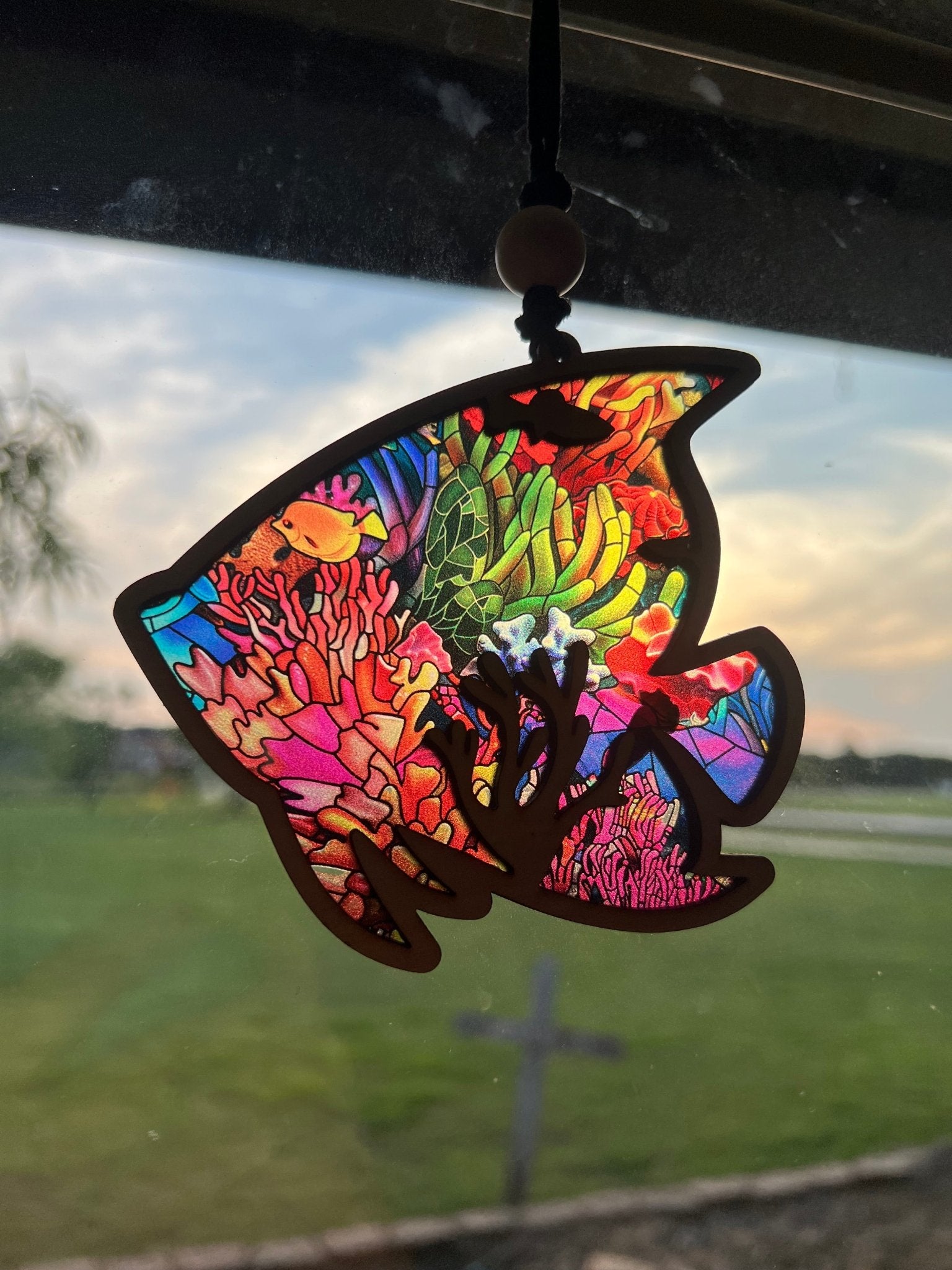 Colorful tropical fish suncatcher with wood and stained glass effect acrylic, 4.75 x 4.5 inches in sunlight.