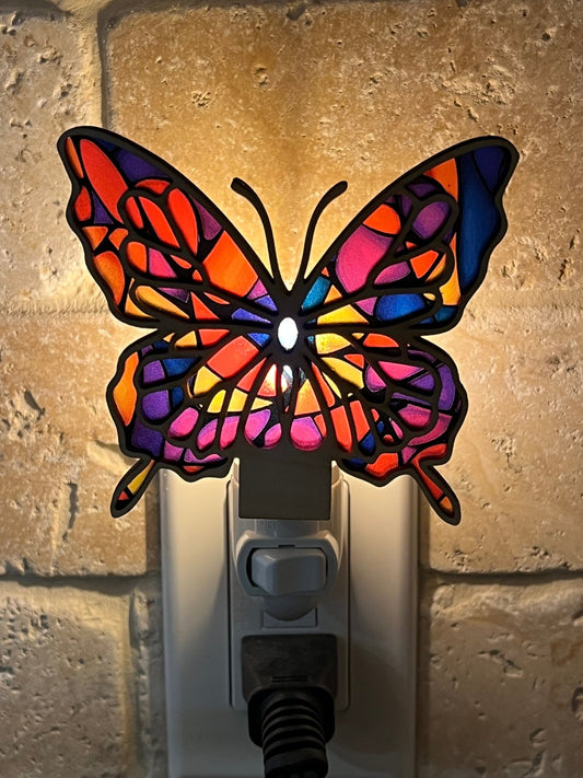 Colorful butterfly nightlight with stained glass effect on wood and acrylic lit in dark.