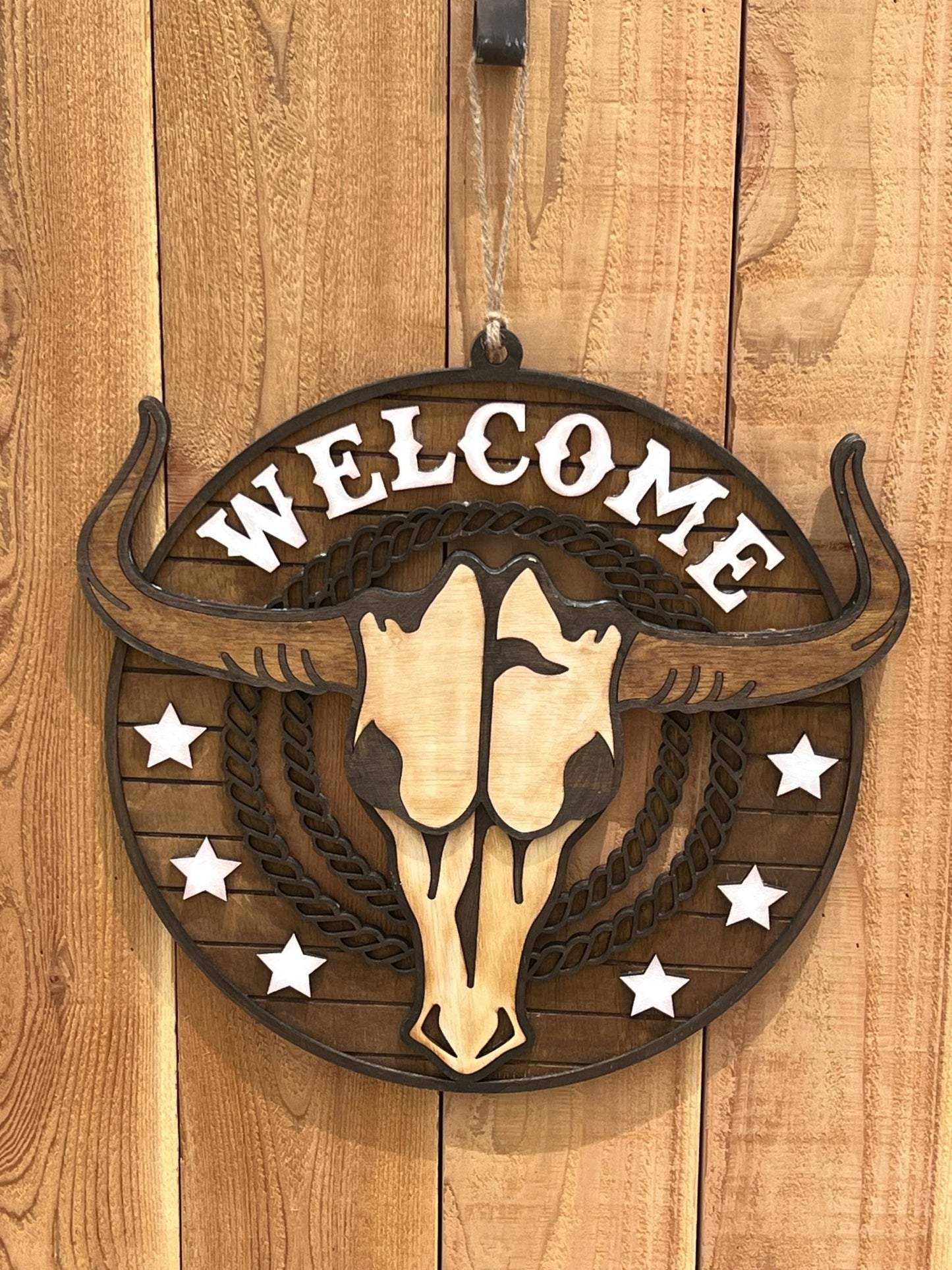 Rustic Longhorn Wood Door Hanger with natural wood texture and warm walnut stain on unpainted fence.