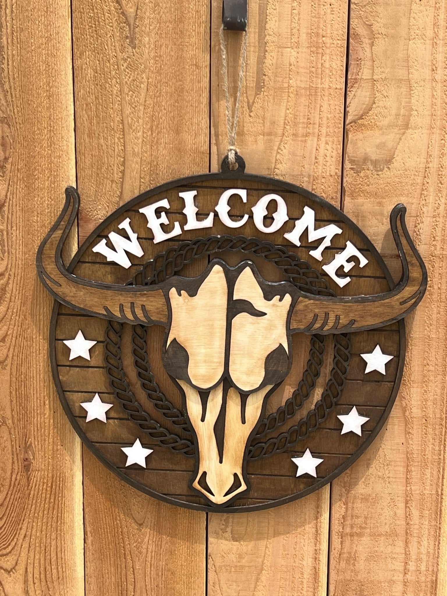 Rustic Longhorn Wood Door Hanger with natural wood texture and warm walnut stain on unpainted fence.