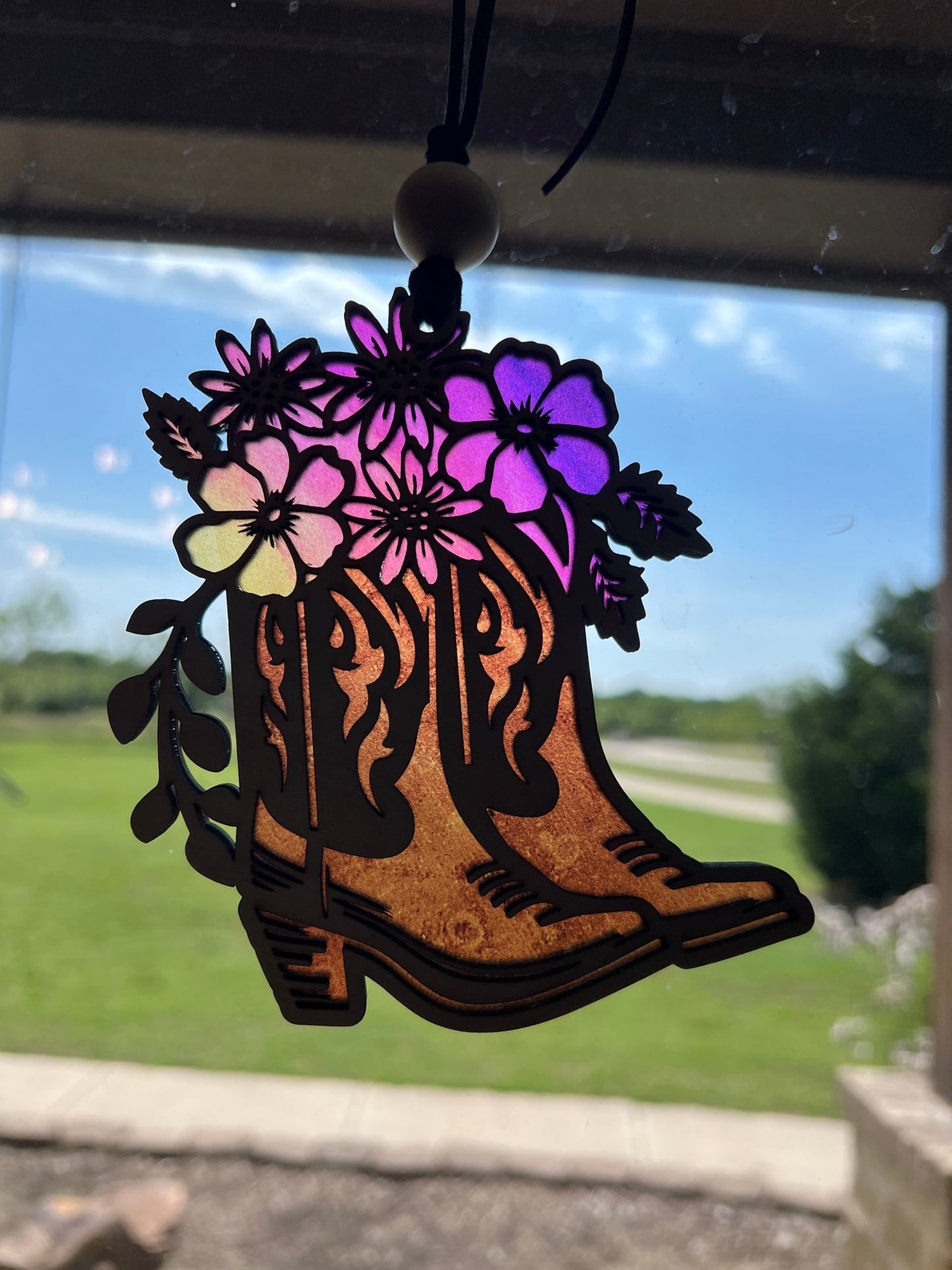 Rustic suncatcher featuring boots and flowers with stained glass effect, made of acrylic and wood , multicolor in sunlight.