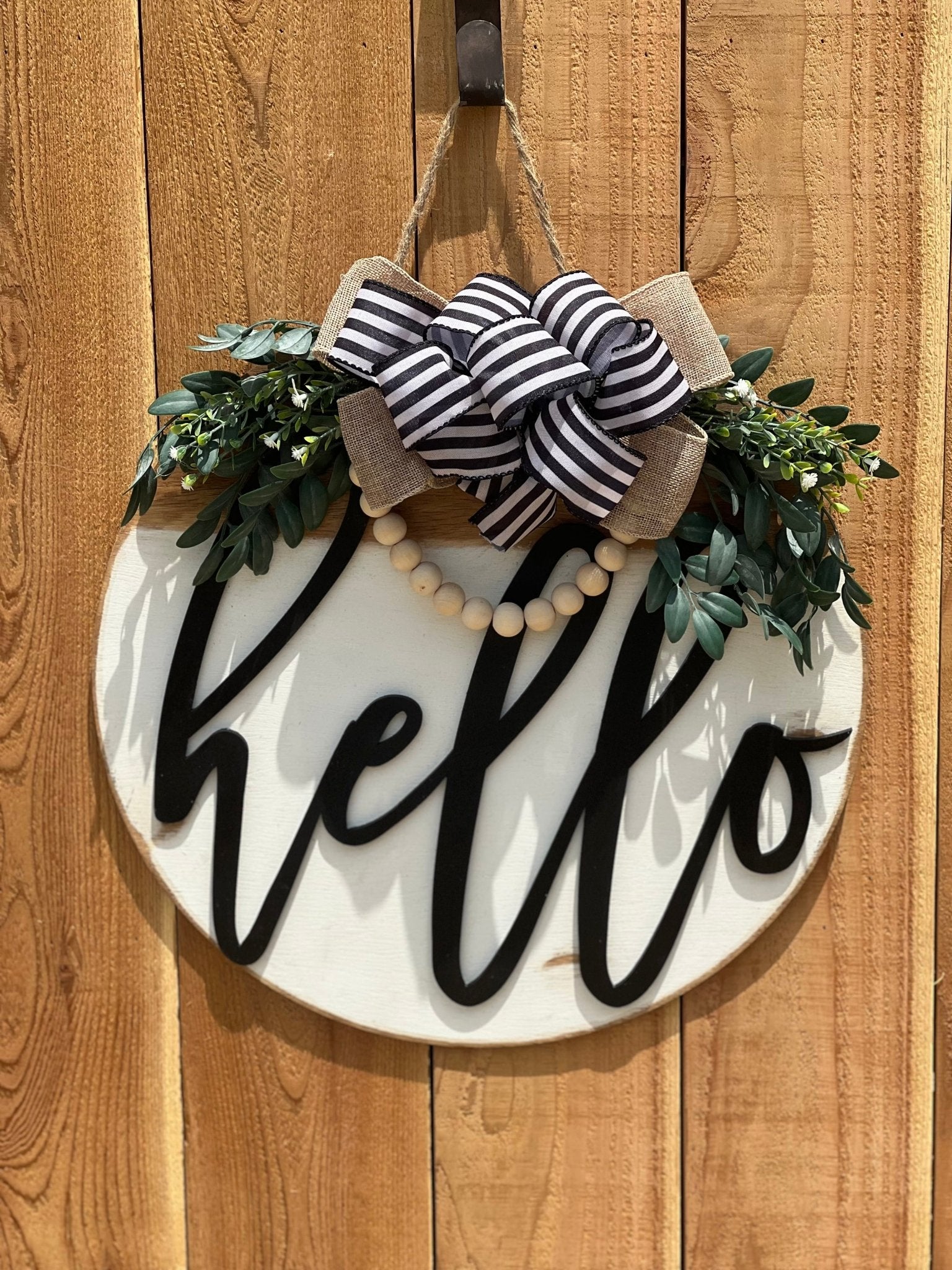 White Hello Door Hanger in rustic wood with black text, 18 inche on unpainted fences.
