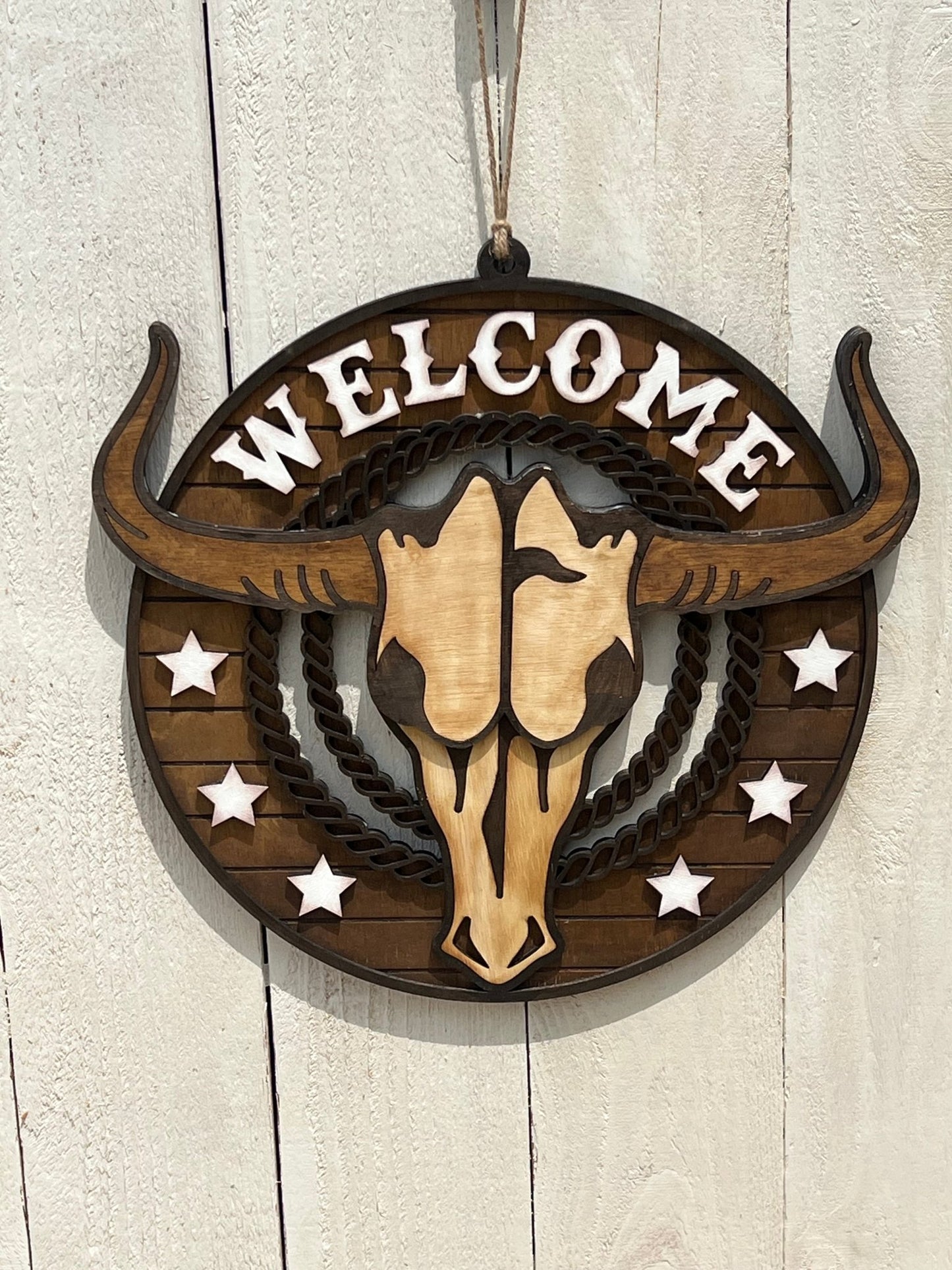 Rustic Longhorn Wood Door Hanger with natural wood texture and warm walnut stain on white fence.