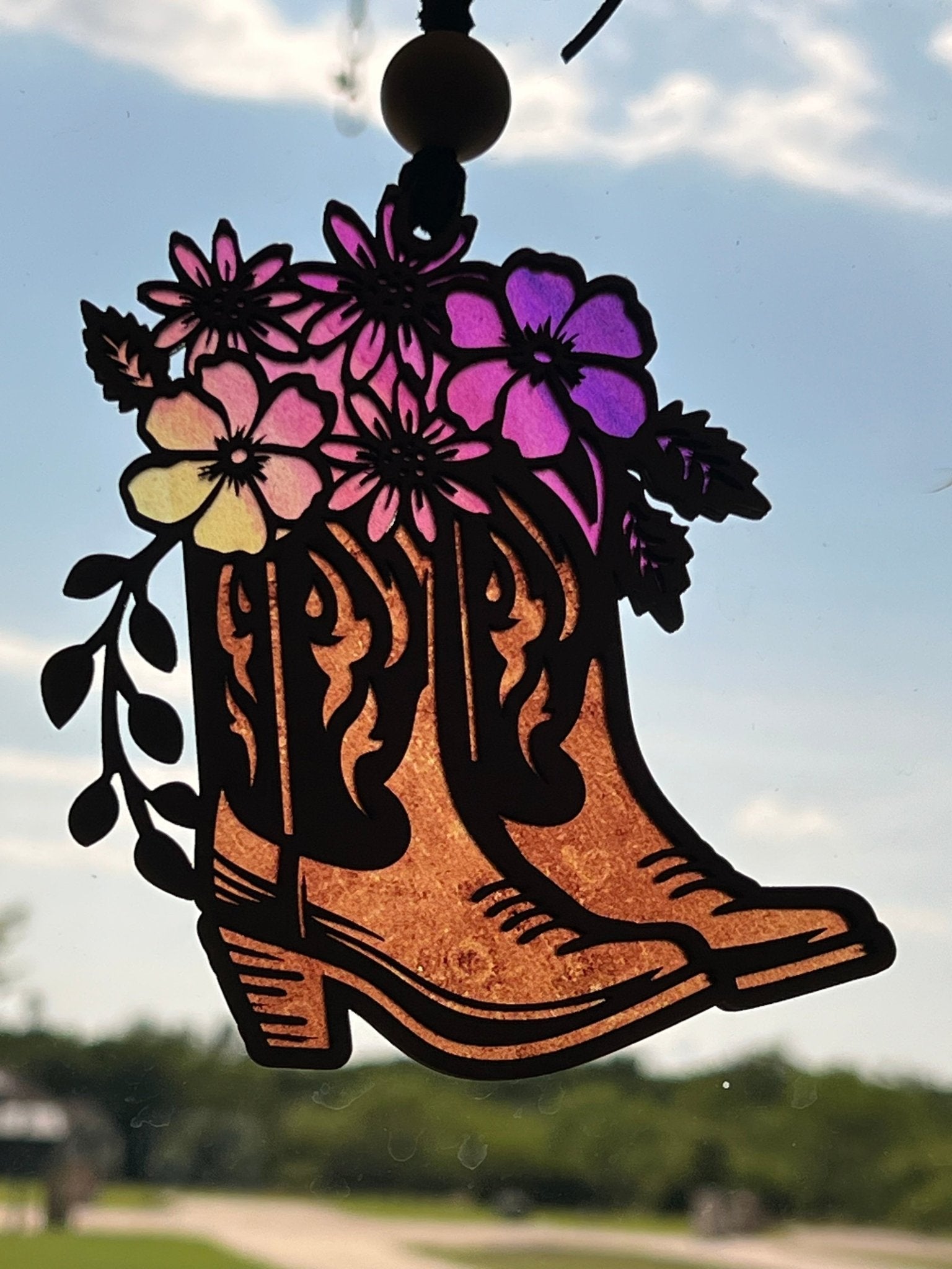 Rustic suncatcher featuring boots and flowers with stained glass effect, made of acrylic and wood in multicolor hues.
