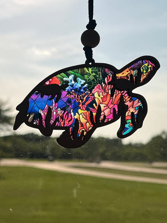 Sea Turtle suncatcher with stained glass effect, wooden and multicolored design in sunlight.