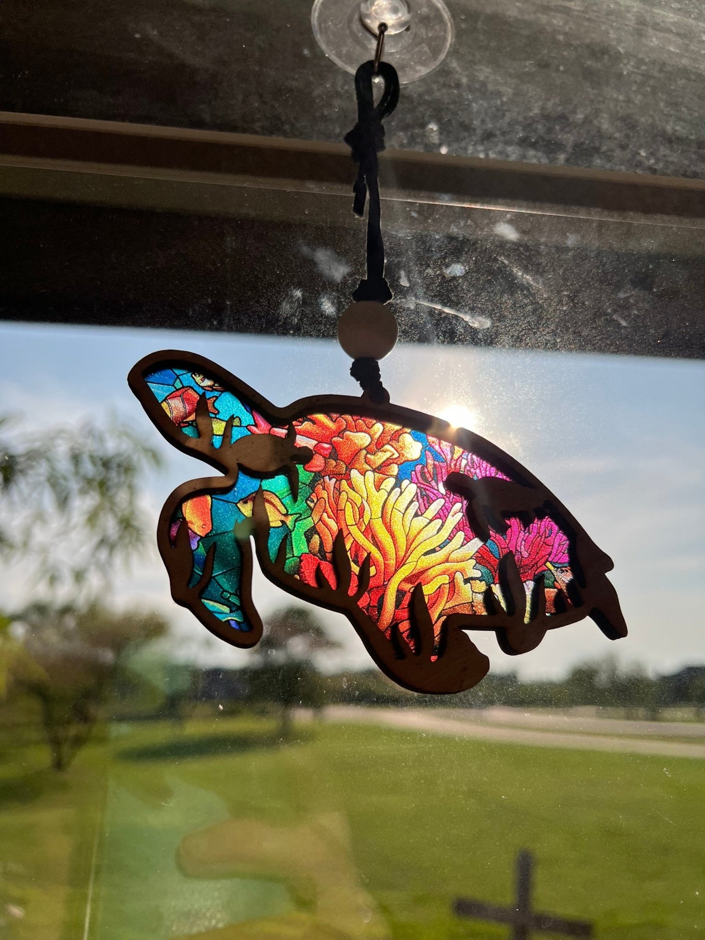 Sea turtle suncatcher with natural wood and multicolor acrylic, perfect for rustic and beach-themed decor in sunlight.