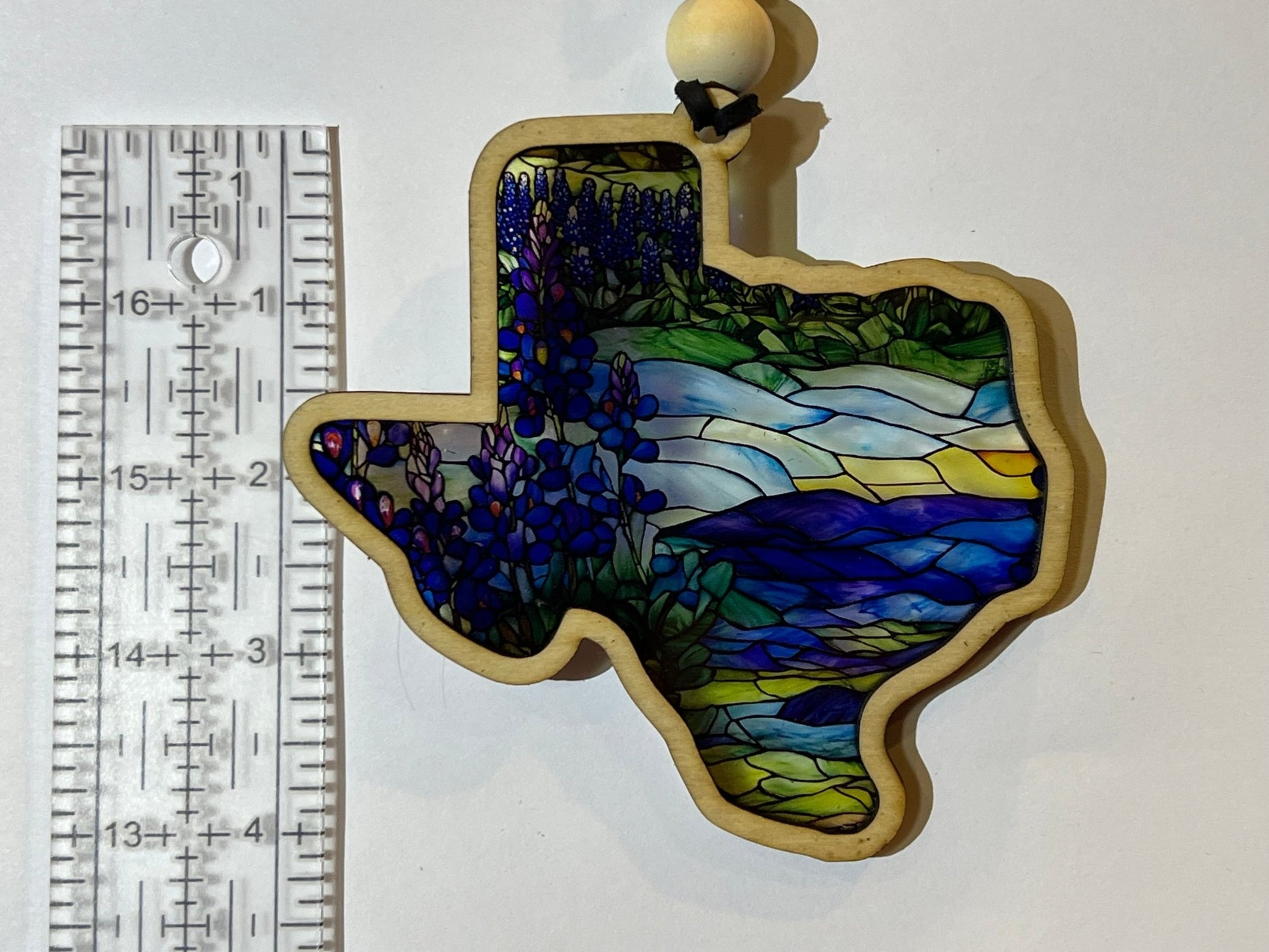 A rustic-modern suncatcher featuring a bluebonnet design with stained glass effect, made of wood and acrylic.