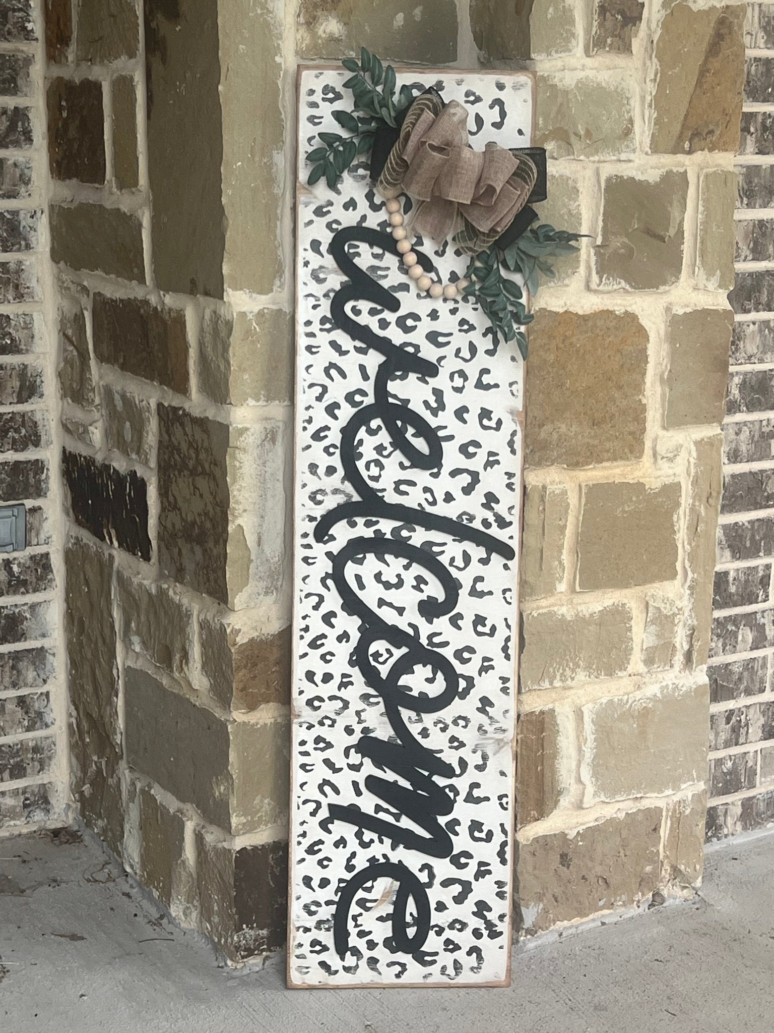 White leopard print wooden door lean, rustic style, perfect for entryway decor leaning against stone.