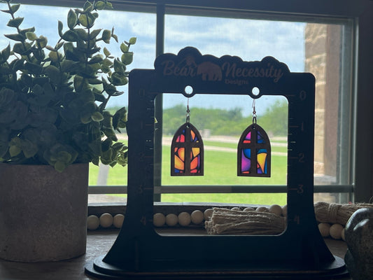 Arched window stained glass effect earrings made of wood and acrylic, showcasing a colorful and rustic design in sunlight.