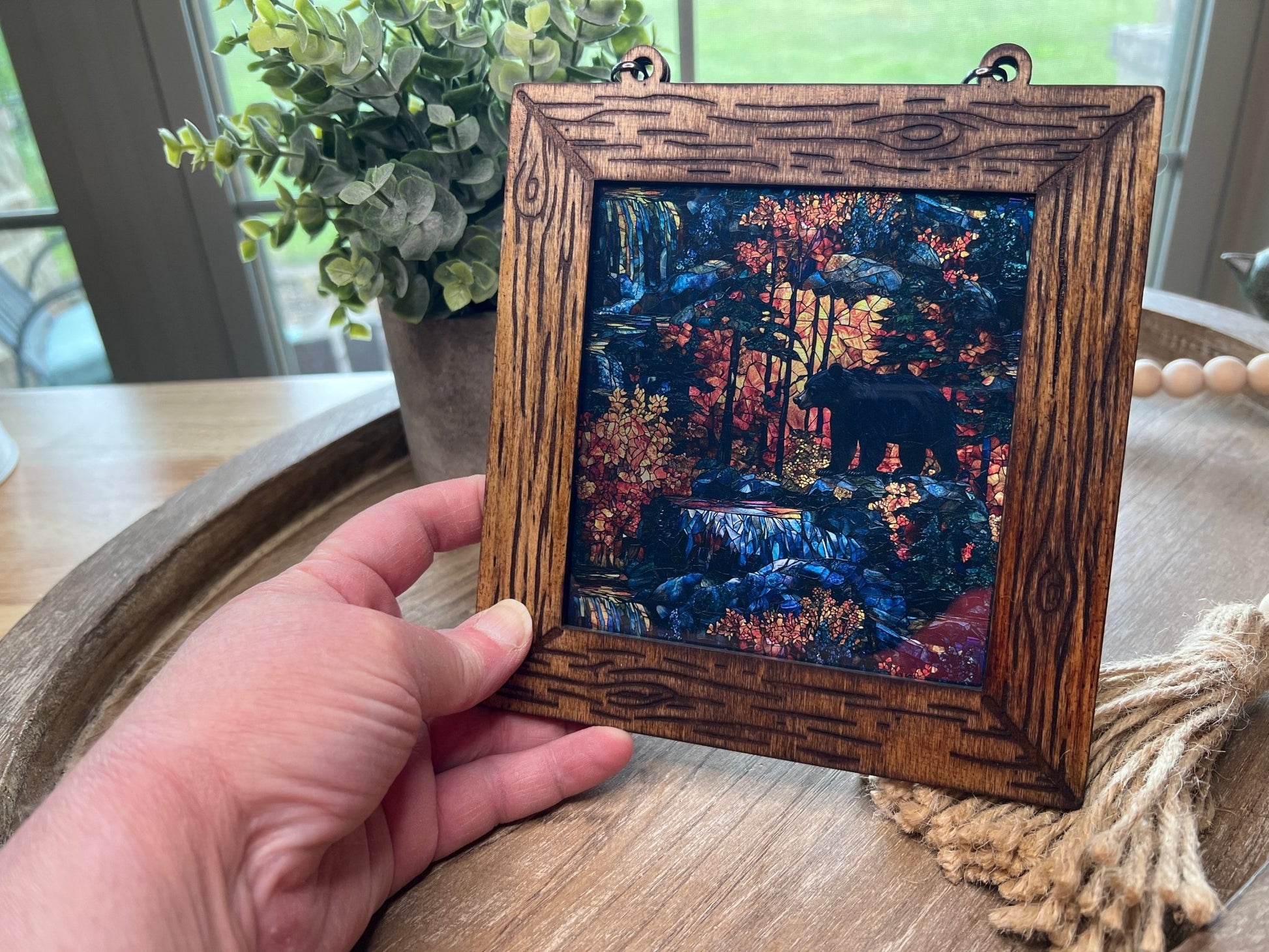 Bear in the Wilderness suncatcher featuring stained glass effect wood and acrylic in a 6-inch multicolor design in hand.