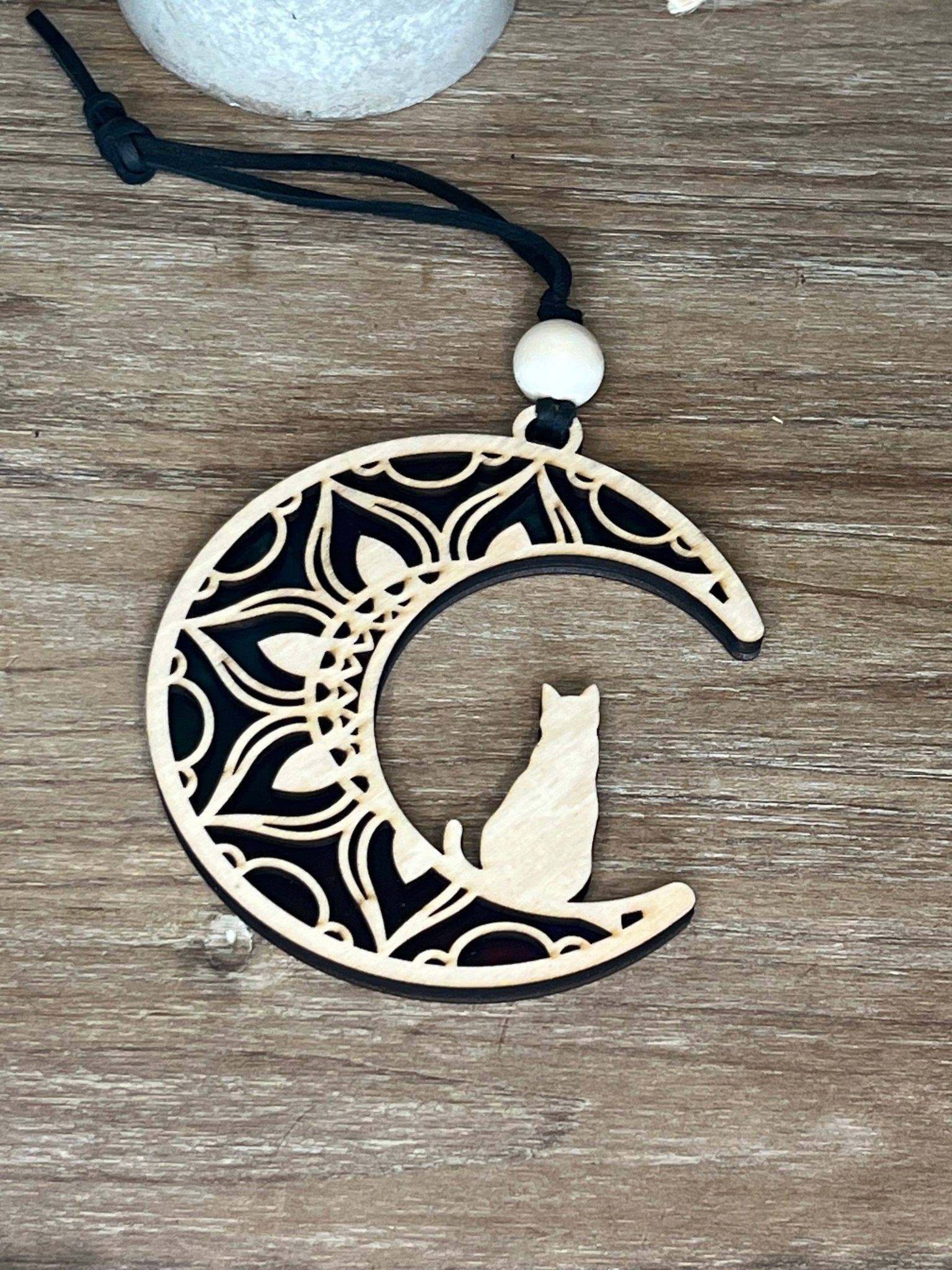 A charming Cat on the Moon Suncatcher made of natural wood and multicolor acrylic.
