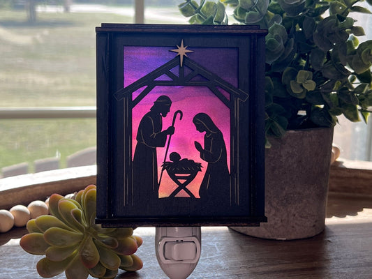 Black wood and multicolor acrylic Christmas Nativity Lantern Nightlight in sunlight on tray.