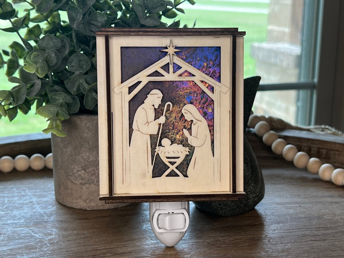 Natural wood Christmas Nativity Lantern Nightlight with multicolor designs in room light unlit.