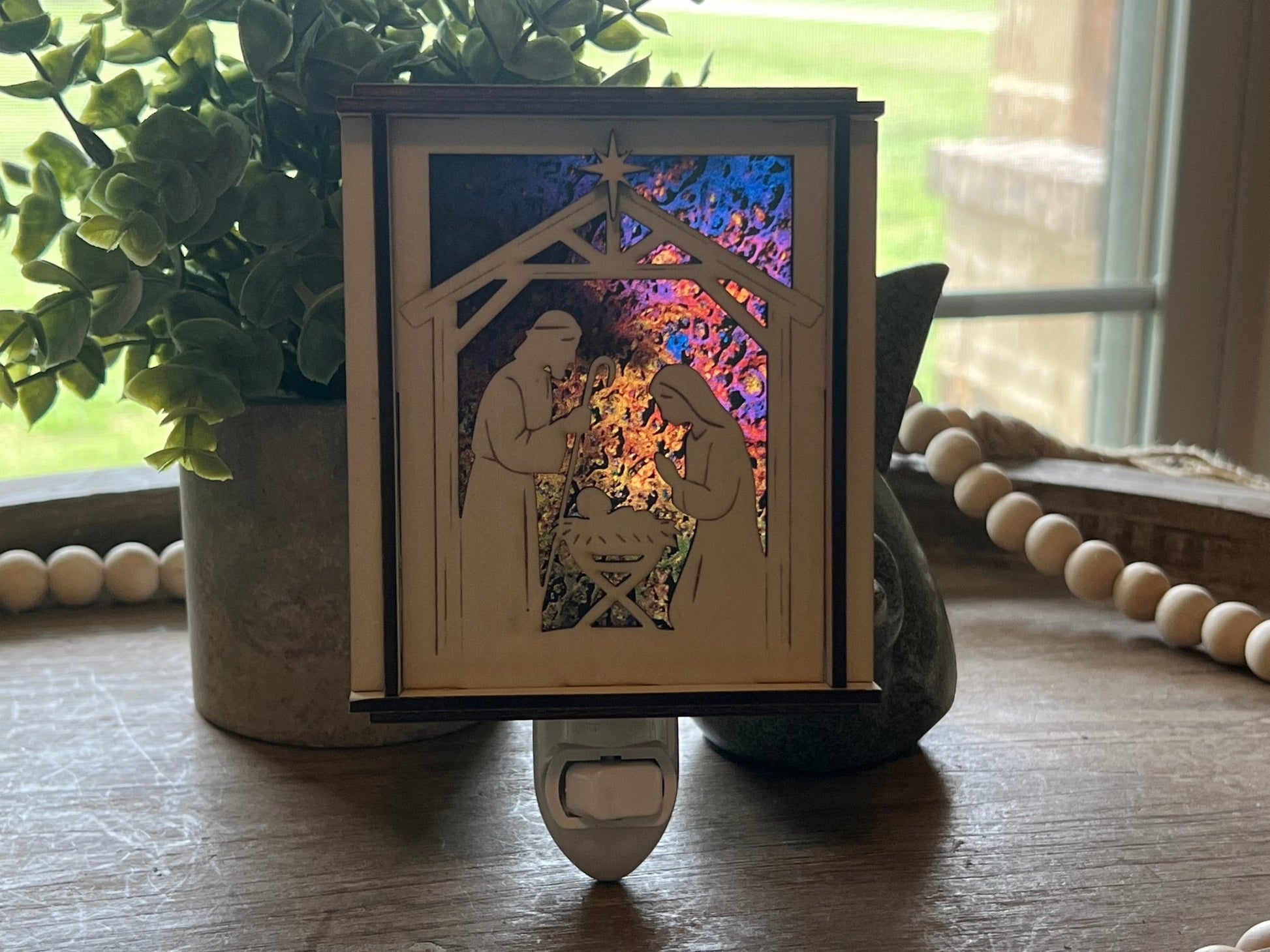 Natural wood Christmas Nativity Lantern Nightlight with multicolor designs in sun.