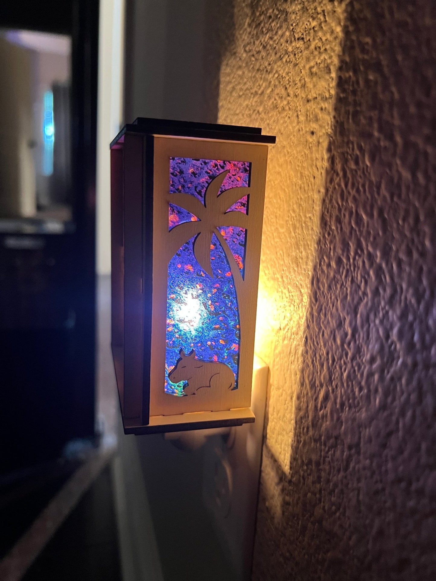 Natural wood Christmas Nativity Lantern Nightlight with multicolor designs in dark hallway right side view.