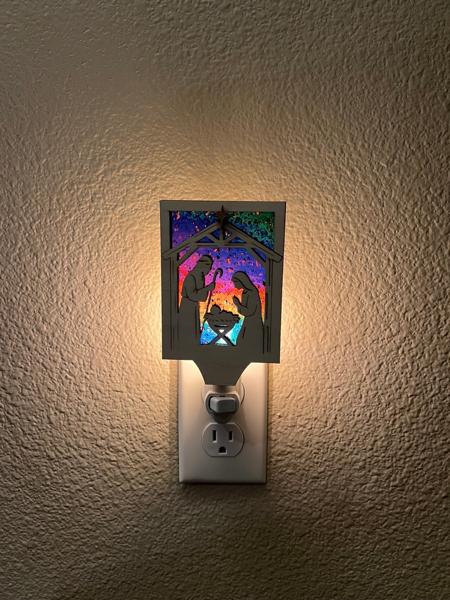 Christmas Nativity Nightlight made of wood and acrylic, featuring natural wood and multicolor elements lighted in dark hallway.