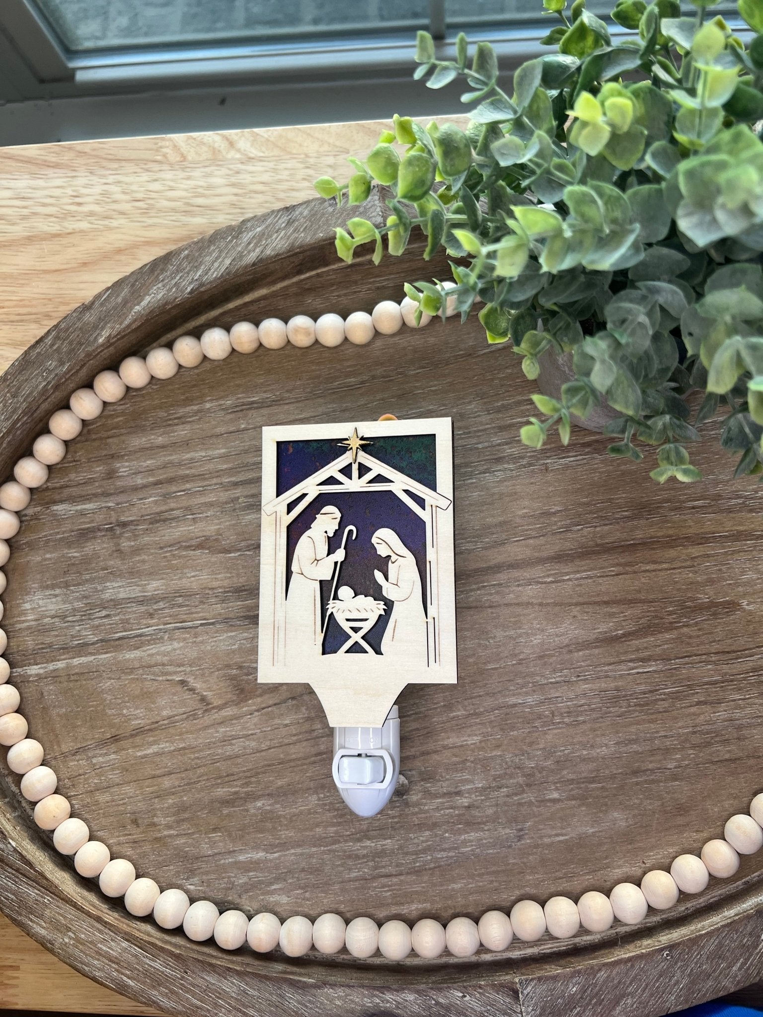 Christmas Nativity Nightlight made of wood and acrylic, featuring natural wood and multicolor elements lying on a tray.