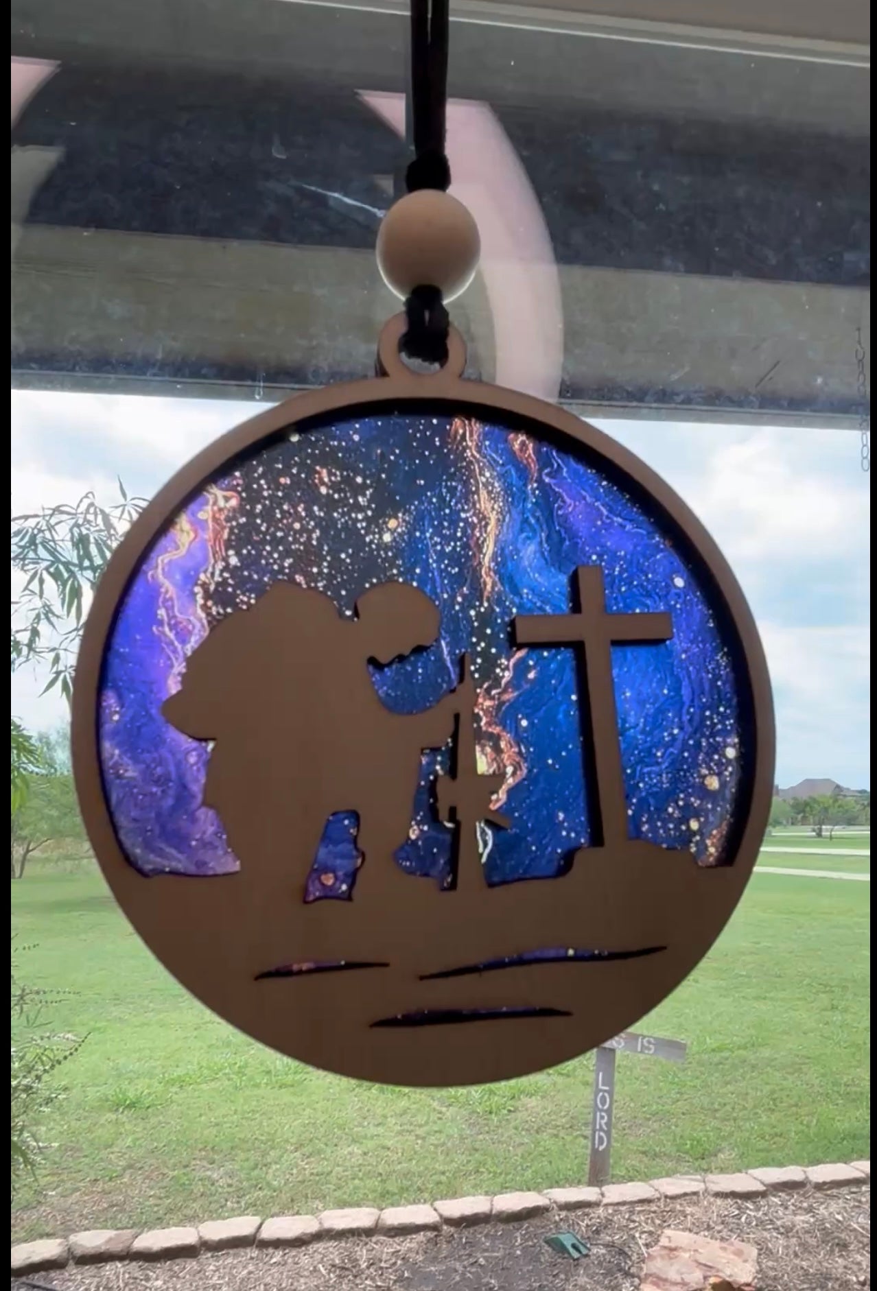 Fallen Soldier suncatcher with natural wood and multicolor acrylic in rustic style in sunlight.