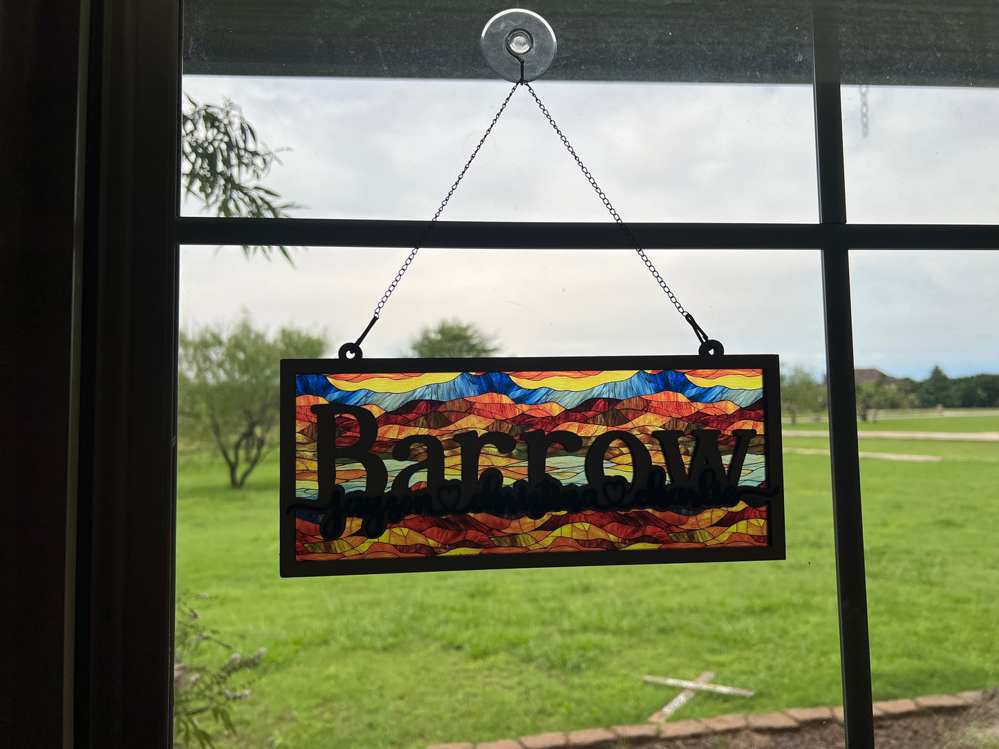 Family Personalized Suncatcher in natural wood and multicolor acrylic, showcasing rustic-modern style in window.