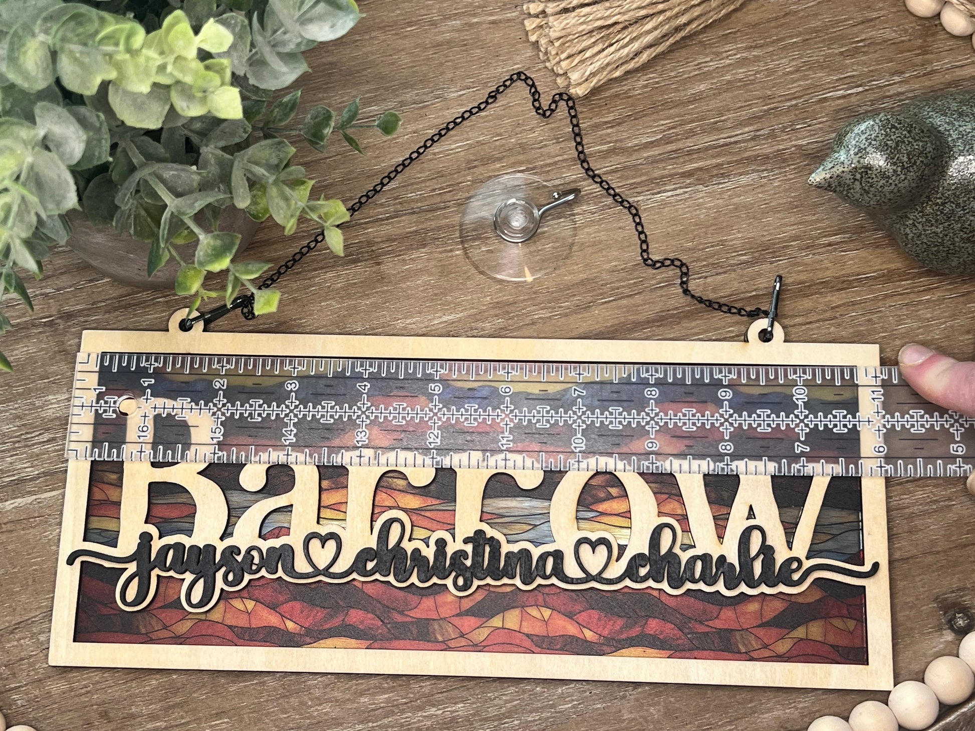 Family Personalized Suncatcher in natural wood and multicolor acrylic, showcasing rustic-modern style in light on tray.