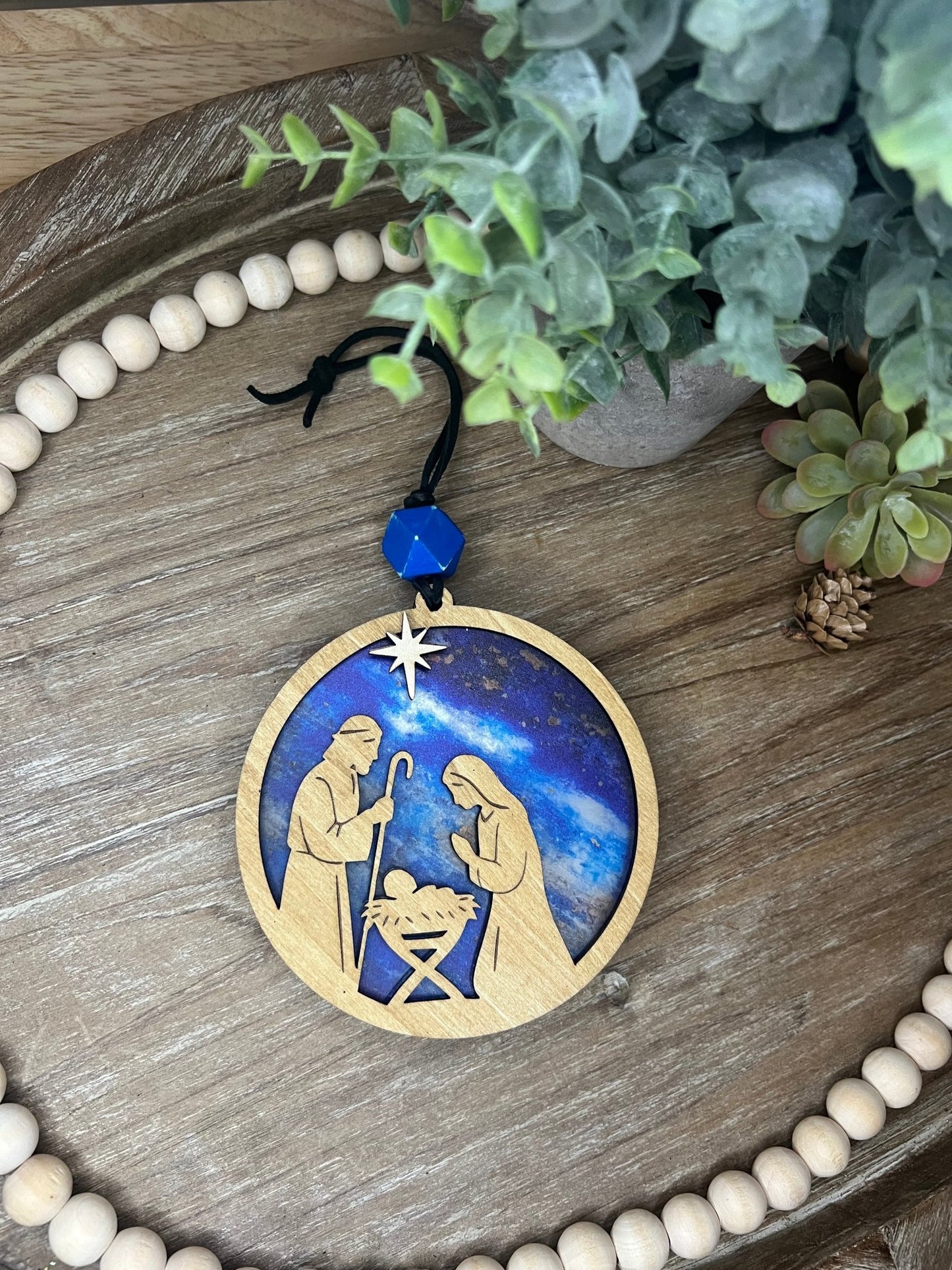 Lighted Christmas Nativity Ornament made of wood and acrylic, featuring a rustic, multicolor design unlit and zoomed in.