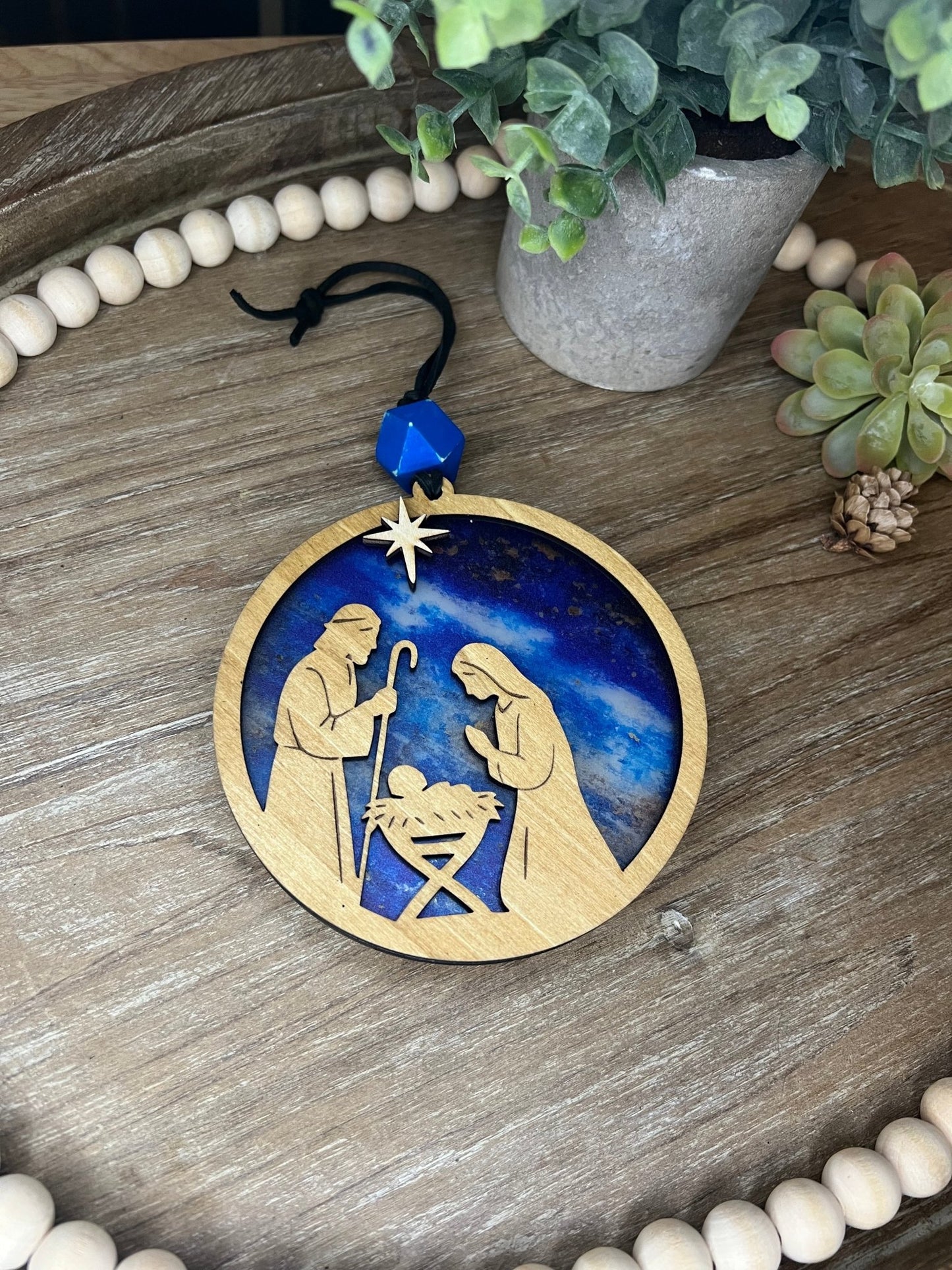 Lighted Christmas Nativity Ornament made of wood and acrylic, featuring a rustic, multicolor design zoomed in and unlit.