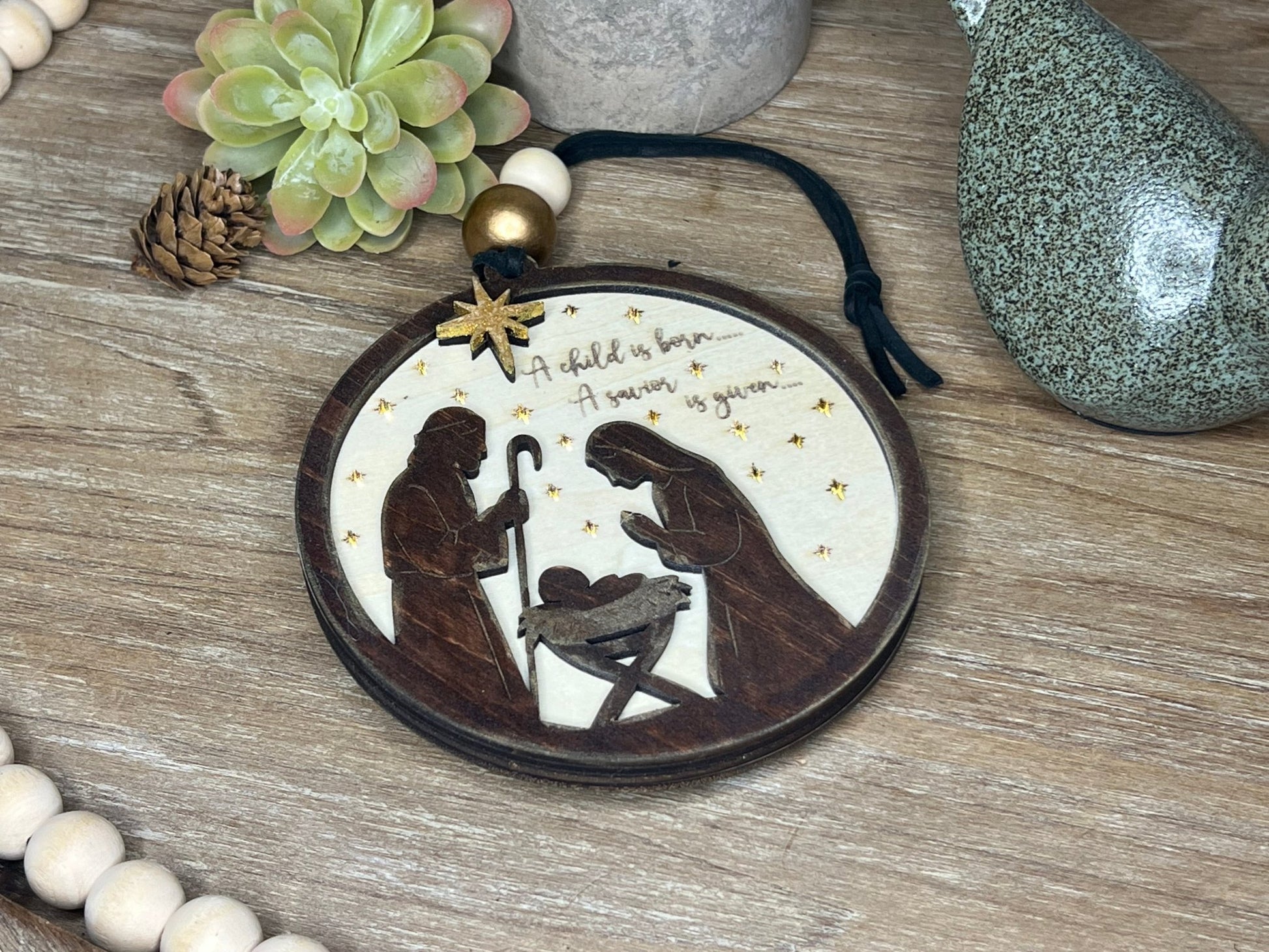 Lighted Christmas Nativity Ornament in natural wood with walnut stain lyning at an angle.