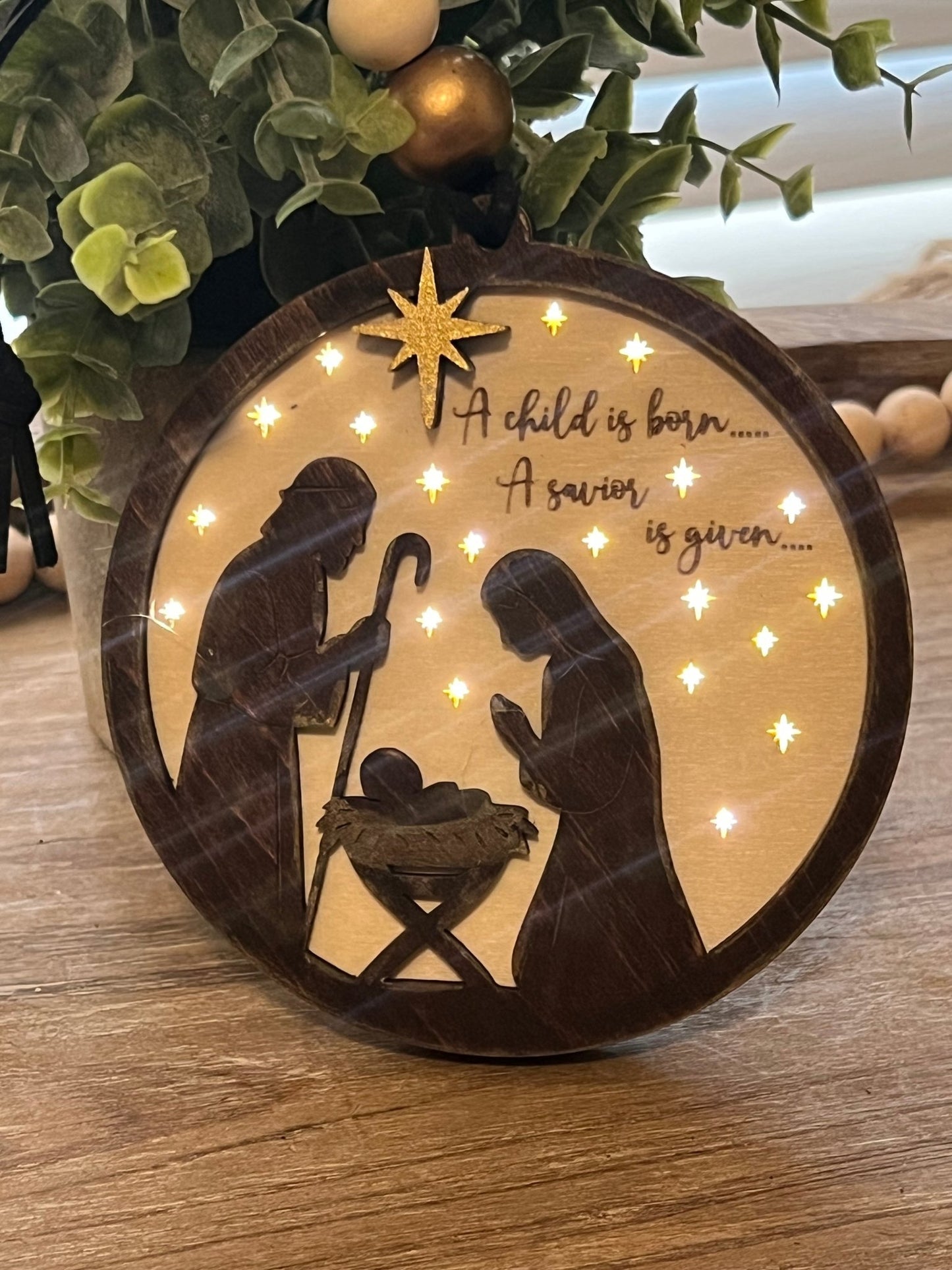 Lighted Christmas Nativity Ornament in natural wood with walnut stain lit in natural light.