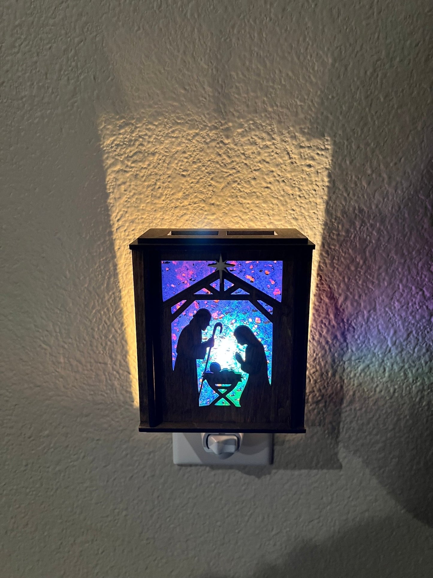 Golden oak stained wooden and acrylic nativity nightlight with rustic charm front view plugged in lit.