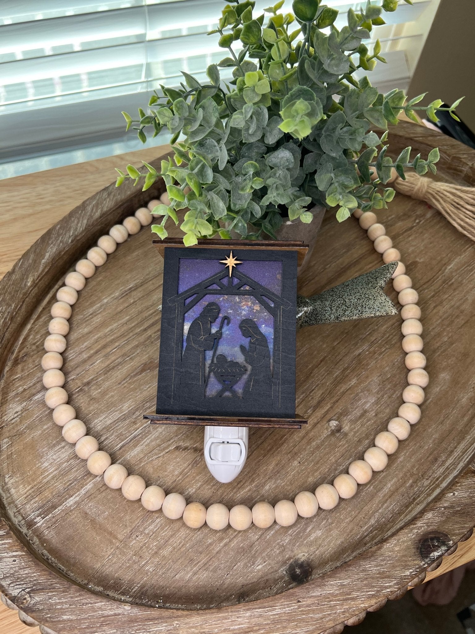 Rustic nativity nightlight lantern made of black wood and golden oak stained acrylic lynig down  with front view and unlit.