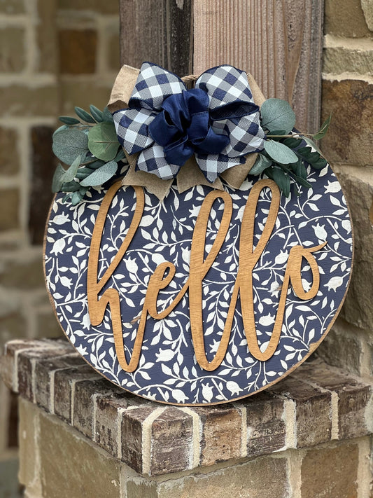 Navy wood hello door hanger with mini flowers on brisks, perfect for rustic entryway decor.