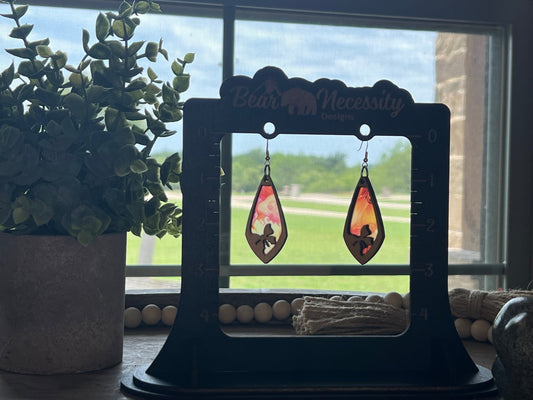Pink and coral butterfly earrings with stained glass effect, crafted from wood and acrylic in sunlight.