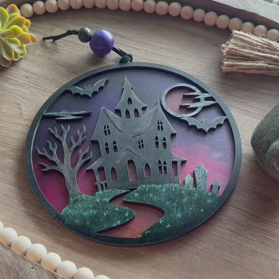 Hand painted suncatcher with a haunted house design on wood and acrylic, in vibrant colors - unlit front view video.