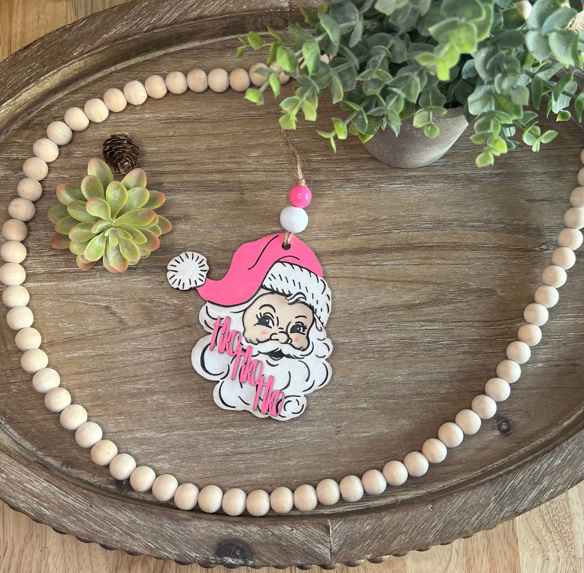 Handmade vintage Santa Christmas ornament with a pink hat, crafted from natural wood zoomed out.