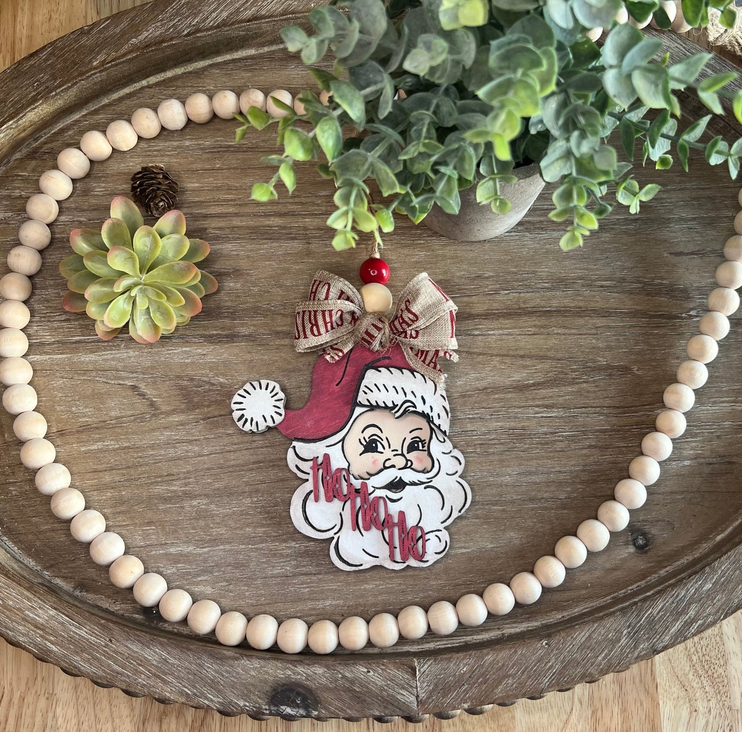 Vintage Santa Christmas Ornament with red hat, wooden and rustic zoomed out.