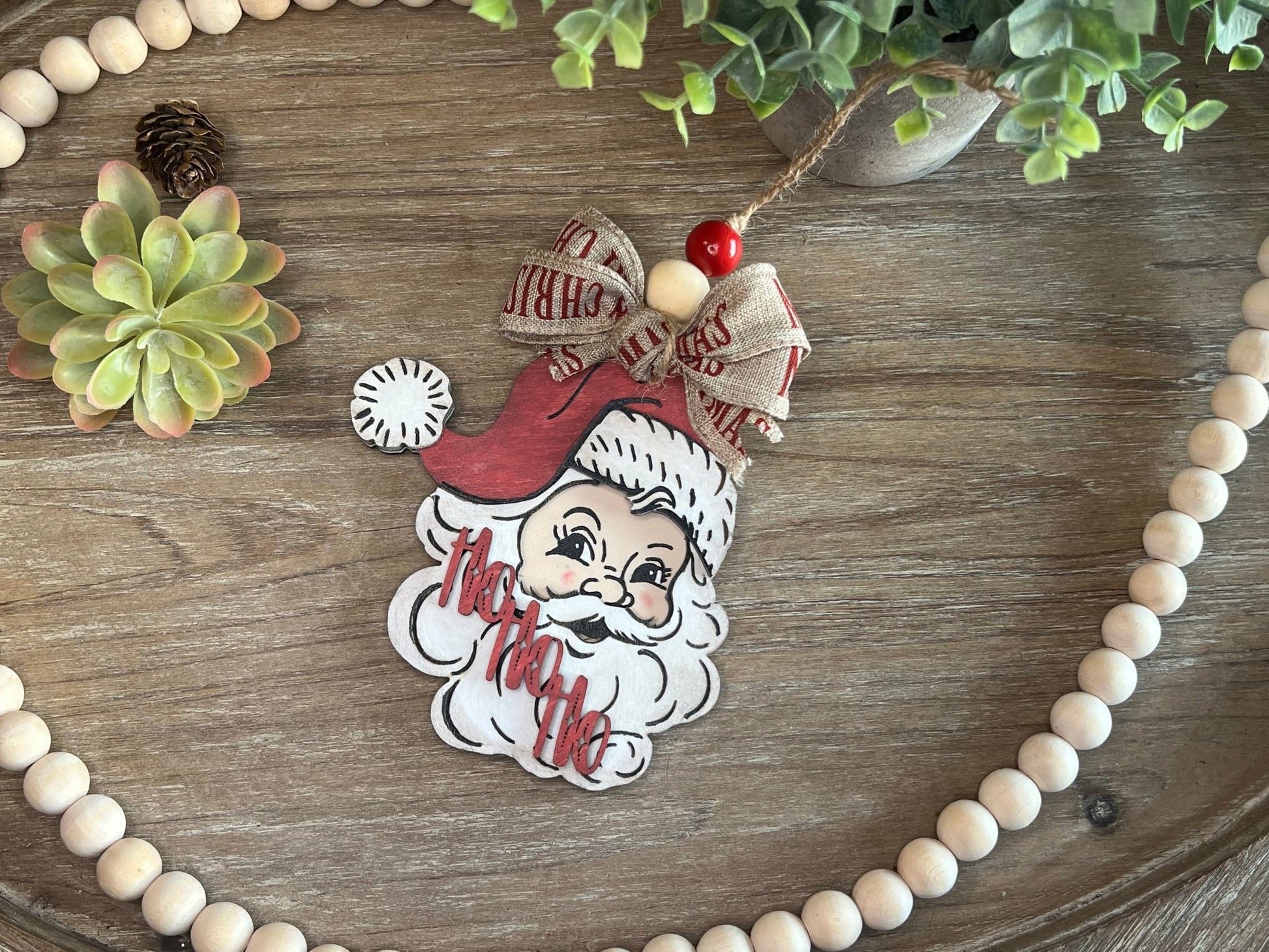 Vintage Santa Christmas Ornament with red hat, wooden and rustic lying on tray.